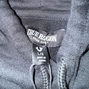 True Religion Black Men’s Hoodie. Light Blue lettering on logo/emblem.
